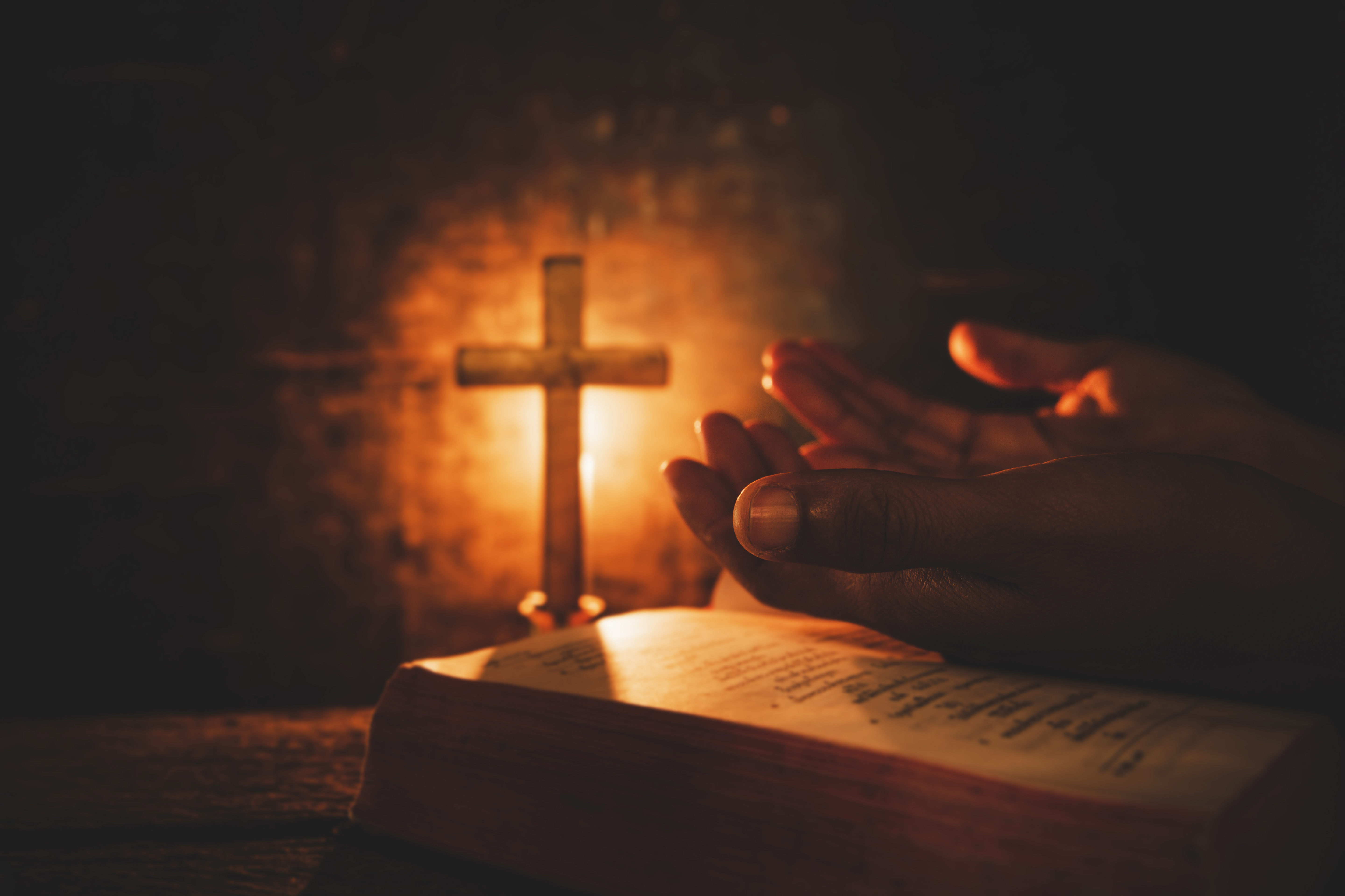 Vintage photo of hand with Bible praying , Hands folded in prayer on a Holy Bible , Spirituality and Religion Concept